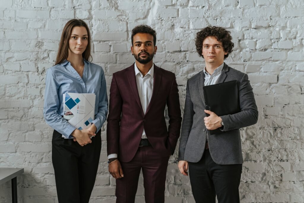 pexels photo 5313182 5313182 Three business professionals standing confidently in an office setting.