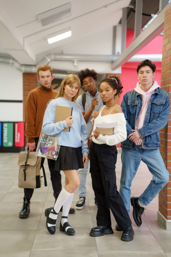 pexels photo 6209364 6209364 Group of diverse high school students standing together in a school corridor with books and backpacks.